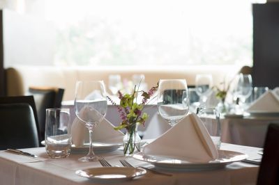 Elegant table setting with folded napkin and flowers.