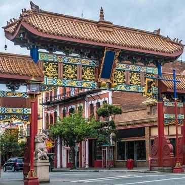 Traditional Chinese archway gate with intricate designs in an urban setting.