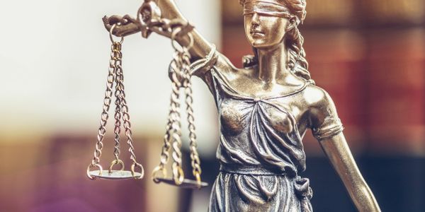 Statue of Lady Justice holding scales, symbolizing fairness and law.