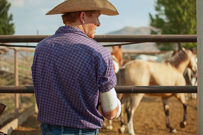 Cowboy wrapping his arm to ride the bull.