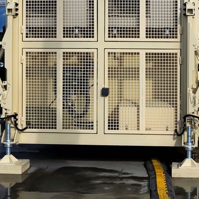 Two lions resting inside a metal cage with a padlock.