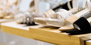 Elegant women's shoes displayed on a wooden shelf in a boutique.