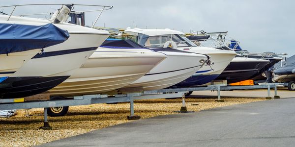 Row of boats on dry dock by the shore.