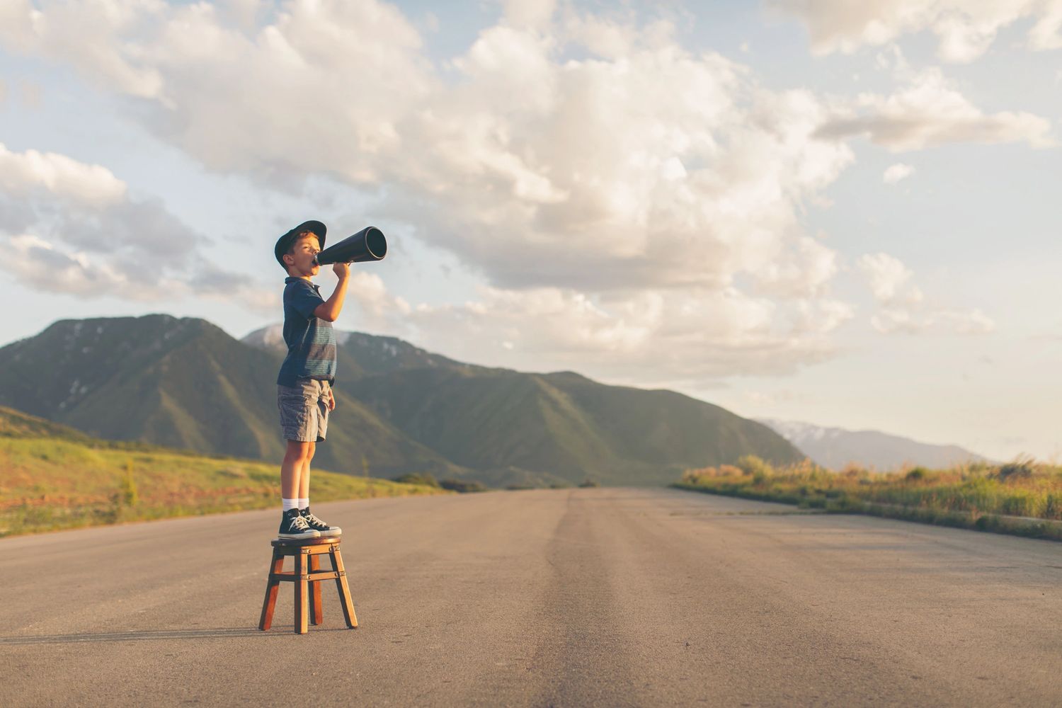 A boy on a stool shouts through a megaphone to signify increasing engagement and driving action