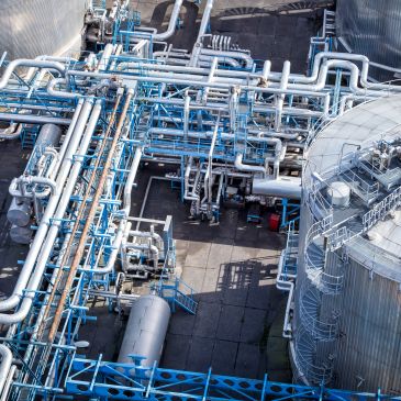 Complex network of industrial pipes and tanks.