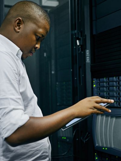 IT technician working on a server rack in a data center.