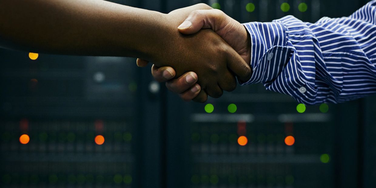 Handshake in a tech server room environment.