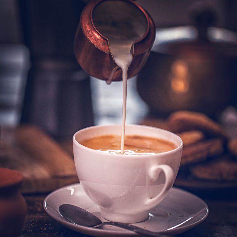 Pouring Milk into Cup of Coffee