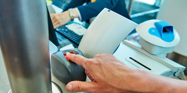 Person scanning fingerprint at a security checkpoint.