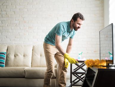 Man cleaning with yellow gloves in living room