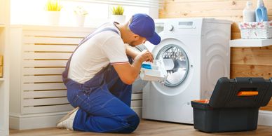 Technician repairing a washing machine detergent drawer.