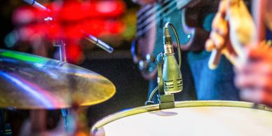 Close-up of a drum set with microphones during a live performance.