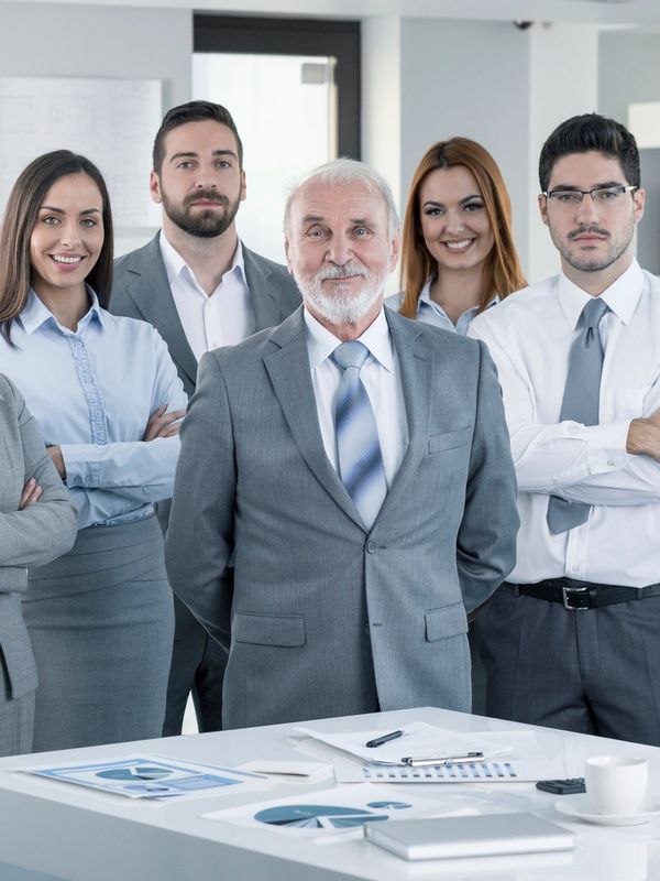 A woman leads a business meeting with attentive colleagues around a table.