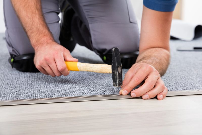 Close-up Of Person's Hand Using Hammer And Nail For Fixing Carpet