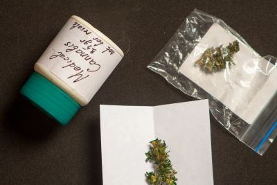 Cannabis samples with labeled container and plastic bag.