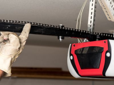 Garage door opener working smoothly: motor unit on track, lifting door effortlessly.


