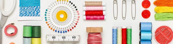 Organized sewing supplies including threads, needles, buttons, and measuring tape.
