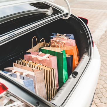 Shopping bags neatly arranged in a car trunk after a shopping trip.