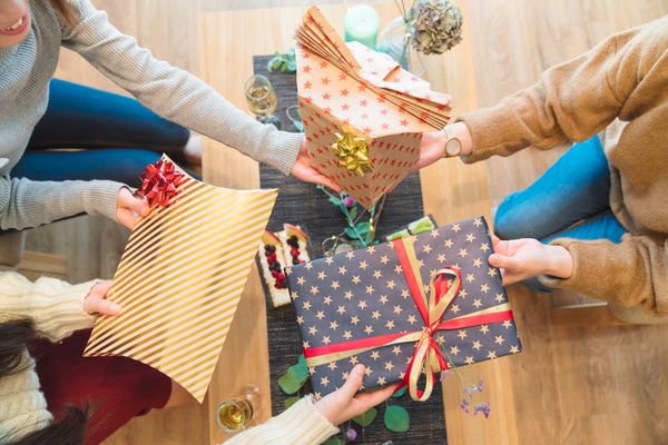 People exchanging wrapped gifts with bows.