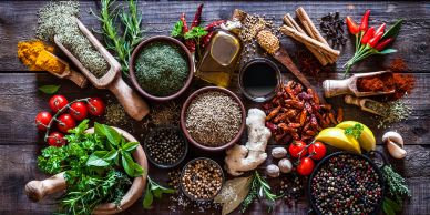Various spices and herbs arranged on a wooden surface.