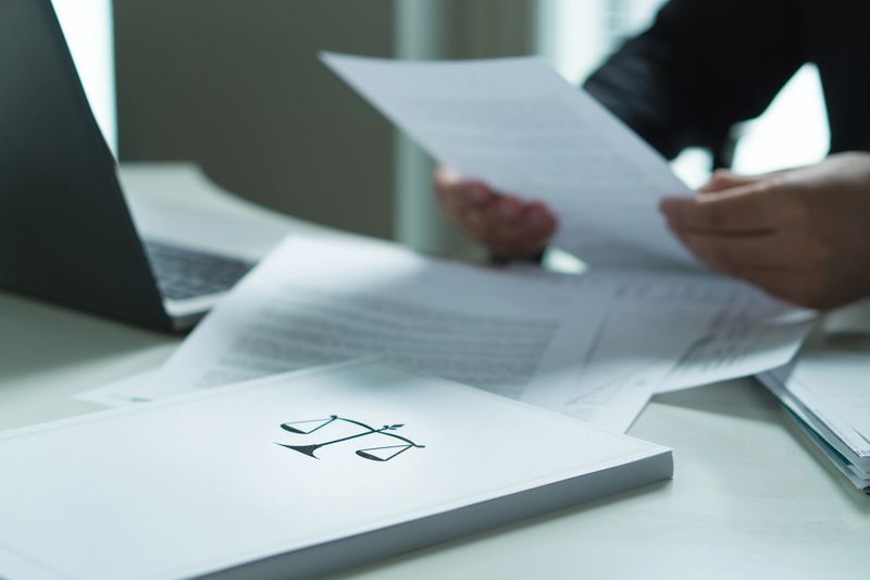 Man holding a legal document in hand. Lawyer holding law paper in office.