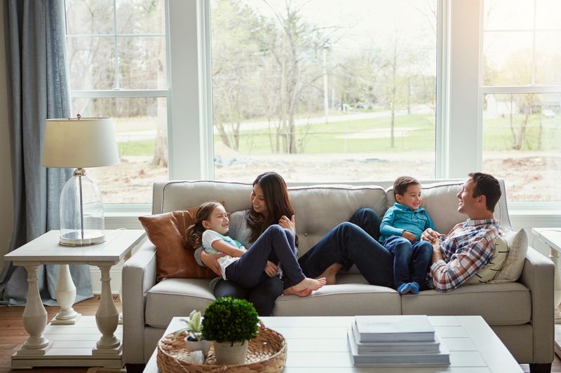 Shot of a happy young family of four relaxing together on the sofa at home