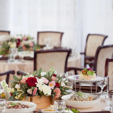 Elegant dining table with floral centerpiece and plated dishes.