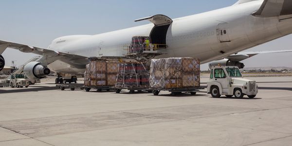 Cargo being loaded onto a large airplane on the tarmac.
