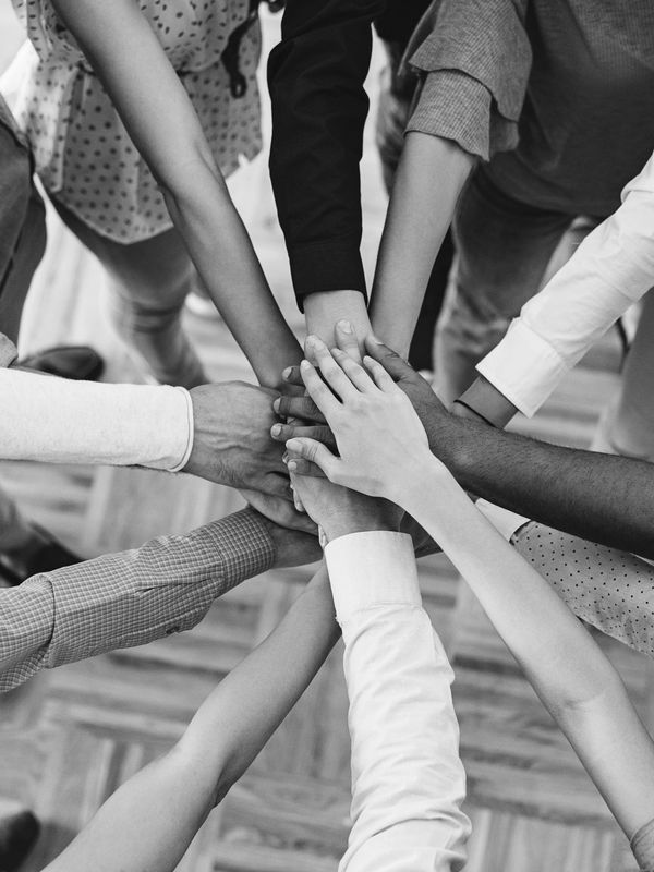 Diverse group stacking hands in unity.