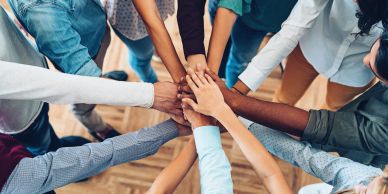 Diverse group joining hands in unity.