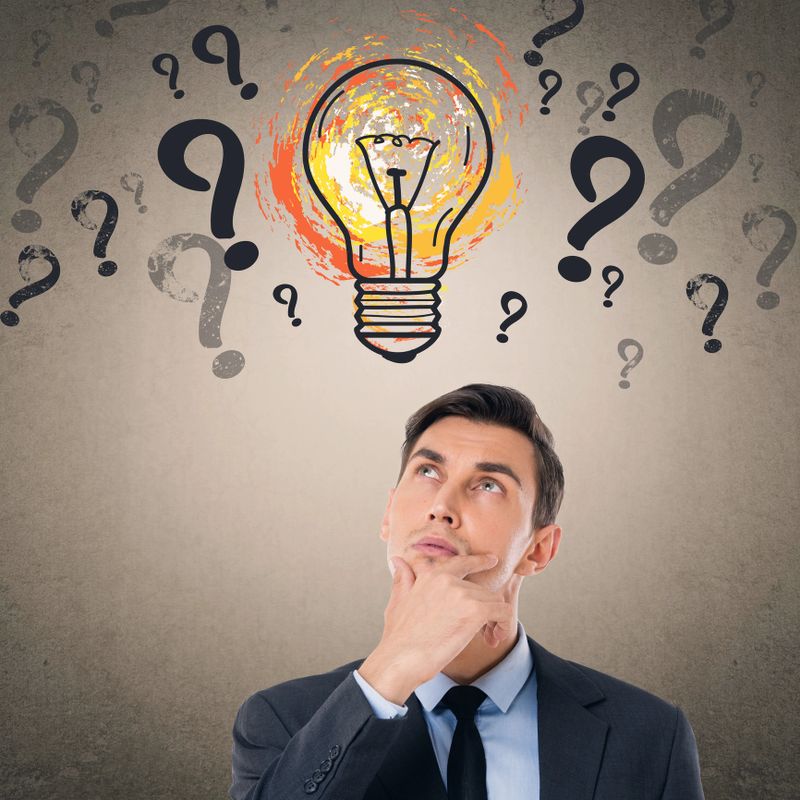 Businessman in front of light bulb icon on wall