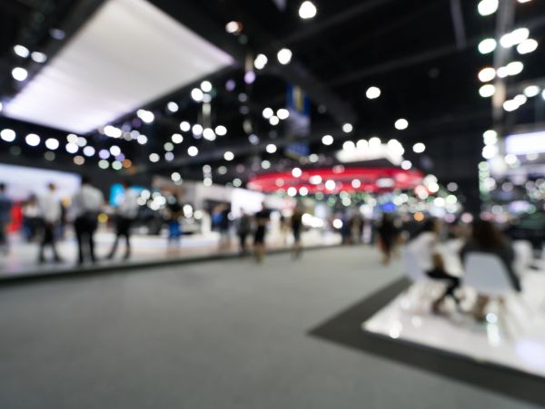 Blurred image of a busy indoor event with lights and people.