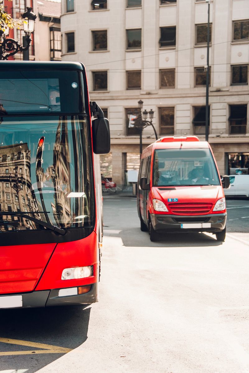A couple red city buses
