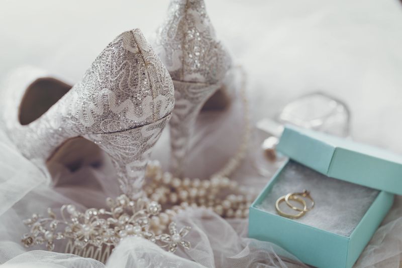 Beautiful gentle arrangement of lace silver high heels and bridal accessories for wedding.