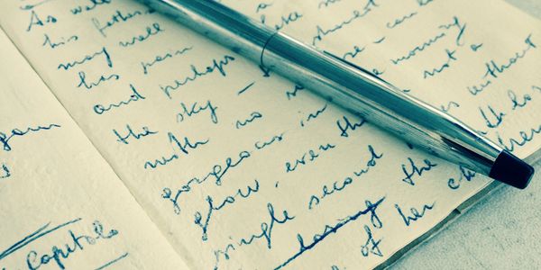 A silver pen resting on a handwritten journal page.