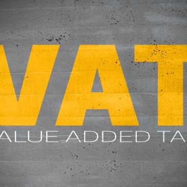 Close-up of the word VAT in large yellow letters on a gray background.