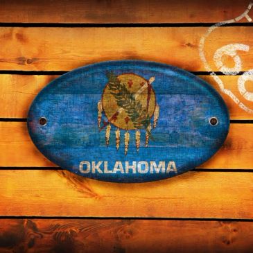 Rustic Oklahoma state sign on wooden background.
