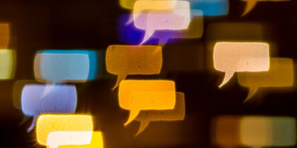 Colorful blurred speech bubbles on a dark background.