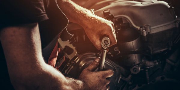 Person using a wrench to repair machinery.