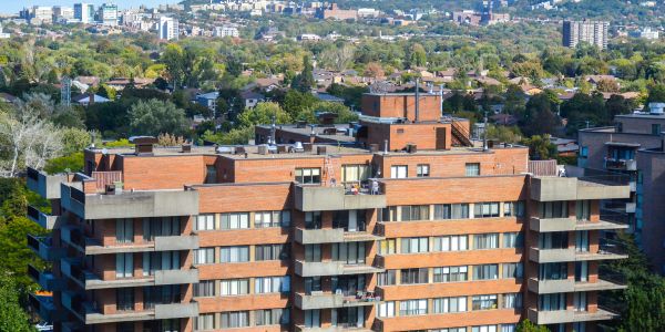 Apartment building with city and greenery in background.