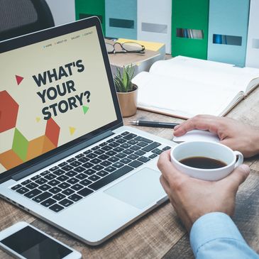 Laptop screen displaying 'What's Your Story?' and person holding a coffee cup.