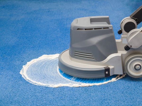 Machine cleaning a carpet with foam.
