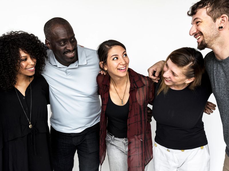 Group of deversity people arms around support together