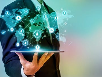 Businessman holding tablet with global social network connections.