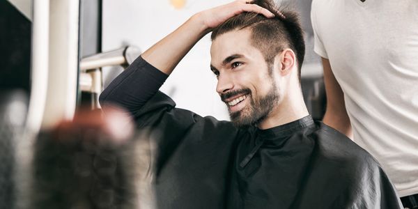 Man smiling while getting a haircut.