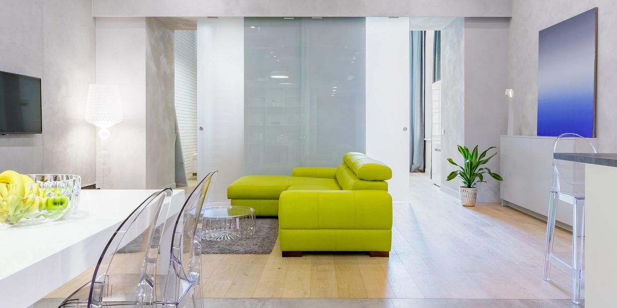 Modern living room with lime green sofa and transparent chairs.