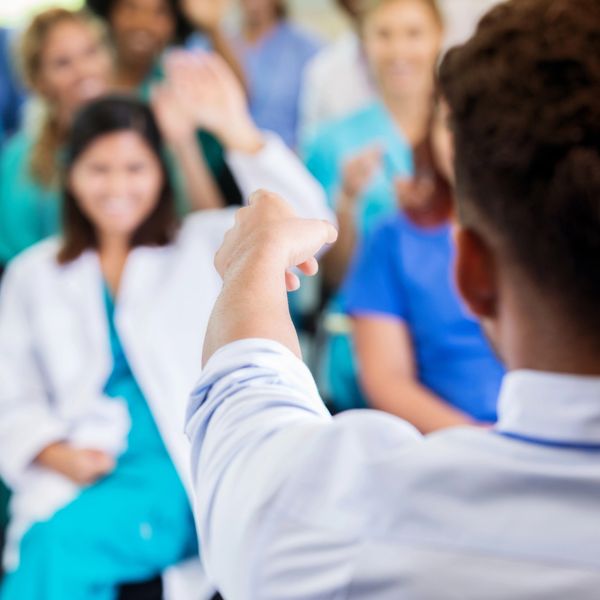 Medical professional engaging with colleagues in a lively discussion.