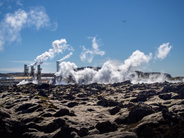 Steam emission from an industrial plant against a blue sky.