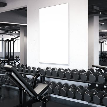 Blank poster in a modern gym with dumbbells and workout benches.