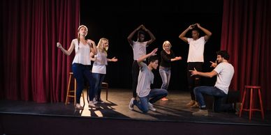 Group of actors performing improvisation on stage.